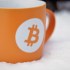 Orangefarbener Becher mit sandgestrahltem BTC-Logo und „Cup & Handle“-Aufschrift